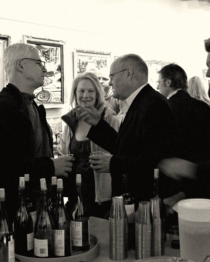 People talking over drinks at a gallery opening.