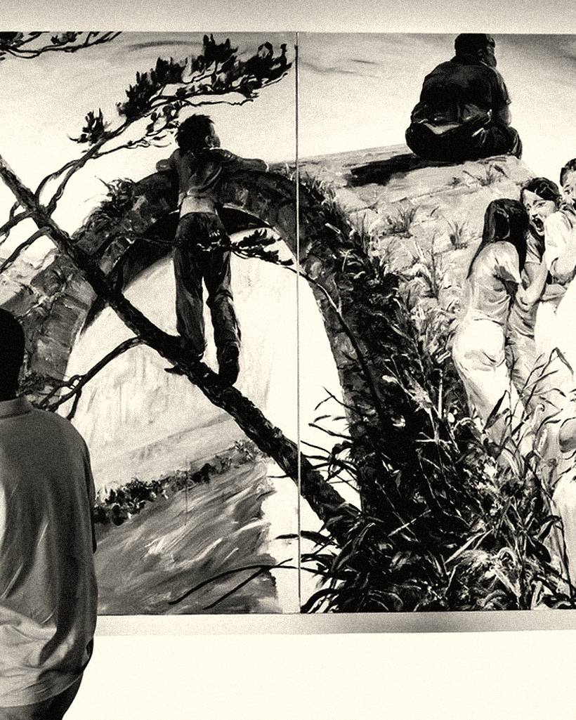 A person standing in front of a large painted mural in a gallery.